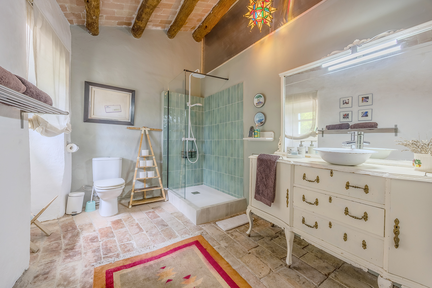 Baño en suite con suelo de barro cocido y ducha de obra