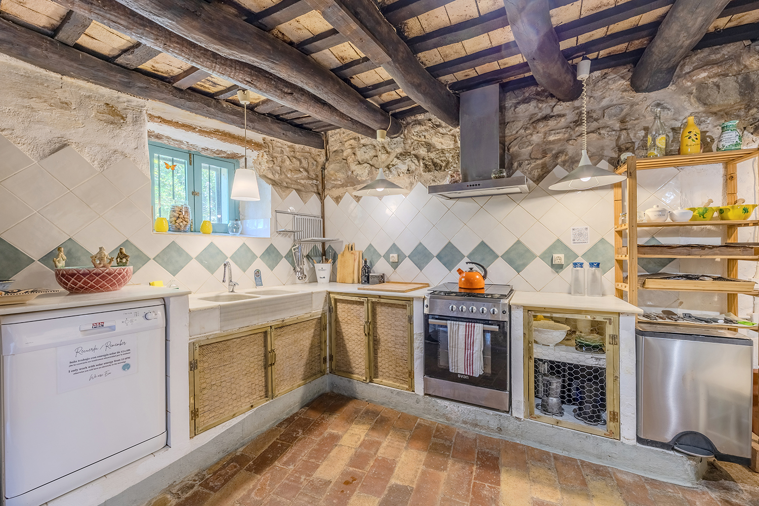 Cocina original de la masía con paredes de piedra