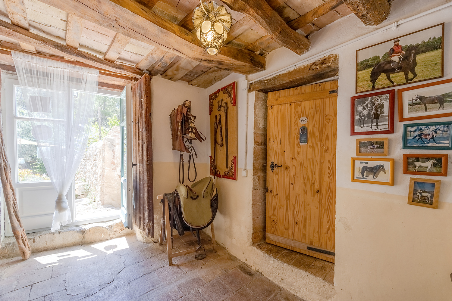Entrada de madera al aseo con motivos equestres
